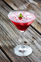 Red Summer martini drink with mint on wooden background