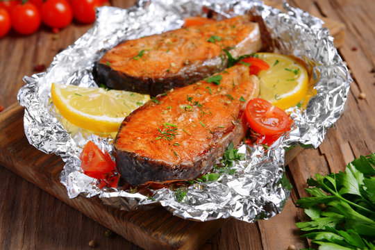 Tasty Baked Fish In Foil On Table Close-up