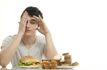 Man holding in front lots of cookies and a big hamburger