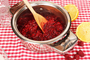 Red raspberries in metal pan, sugar, lemon and