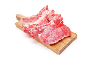 Three raw beefsteaks on a wooden cutting board