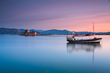 Boat and Burtzi castle in Nafplio, Greece.