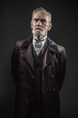 Vintage characteristic senior man with gray hair and beard. Stud