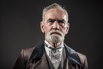 Vintage characteristic senior man with gray hair and beard. Stud