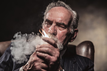 In chair sitting characteristic senior business man. Smoking cig
