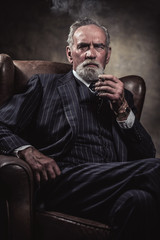 In chair sitting characteristic senior business man. Smoking cig