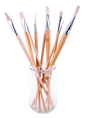 Paint brushes in glass jar isolated on white