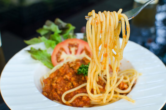 italian spaghetti topped with bolognaise, or bolognese, sauce wi