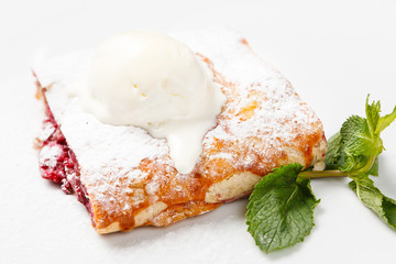 Cherry strudel with ice cream and mint leaf.