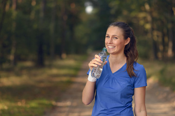 Sportliche junge Frau trinkt aus einer Wasserflasche