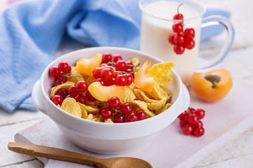 Cornflakes in bowl with red сcurrant
