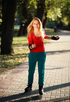 Happy young girl enjoying roller skating in park
