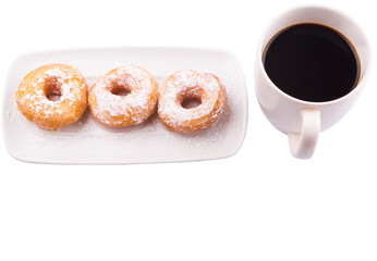 A mug of coffee and homemade doughnut with sugar toppings 