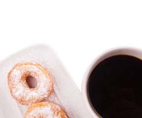 A mug of coffee and homemade doughnut with sugar toppings 