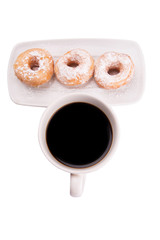 A mug of coffee and homemade doughnut with sugar toppings 