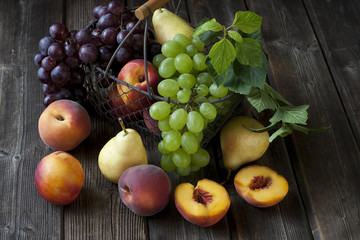 Naklejka na ściany i meble Still life with fruits in a basket on the table