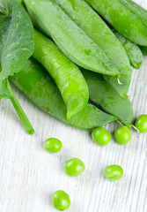 fresh pea pods on wooden surface