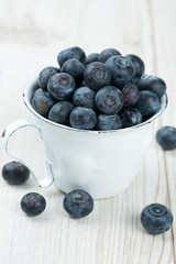 blueberries in a metallic cup on wooden table
