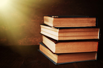Antiquarian books on wooden table with warm light
