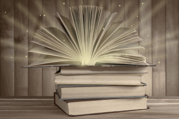 Antiquarian books on wooden table with warm light