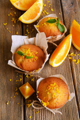 Tasty cupcakes with orange on table close-up