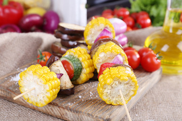 Sliced vegetables on picks on board on table close-up