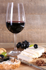 beautiful still life with wine, cheese and ripe grape