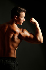 Handsome muscle young man on dark background