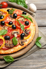 Delicious pizza served on wooden table