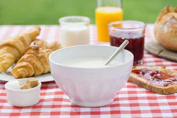 Breakfast with milk, orange juice, croissant, marmalade and brea