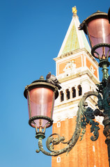 Fototapeta na wymiar The lantern on San Marco Square, Venice. Pigeon is sitting on la