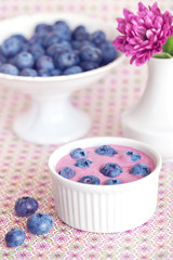 blueberry yogurt with a fresh berries in a cup on the table .