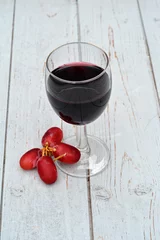 Fotobehang Glas rode wijn met druiven. © trinetuzun