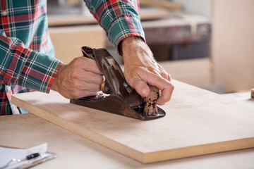 Carpenter's Hand Using Plane On Wood