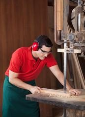 Carpenter Cutting Wood With Bandsaw