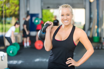 Fototapeta premium Happy Female Athlete Lifting Kettlebell