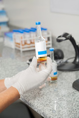 Technician Holding Specimen Bottle In Laboratory