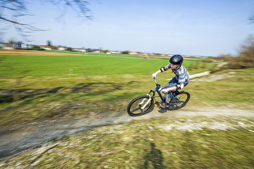 Obraz premium teenage boy racing with his dirt bike