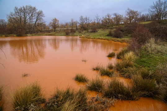 Unusual orange color of the water in the small lake, Pueblos roj
