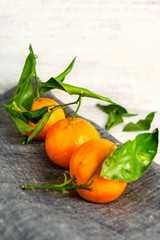 Tangerines on gray napkin. Wooden background.