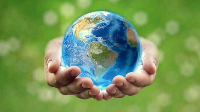 Earth in man's hands – green background