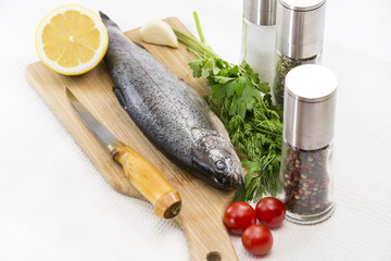 raw fish on a cutting board and knife