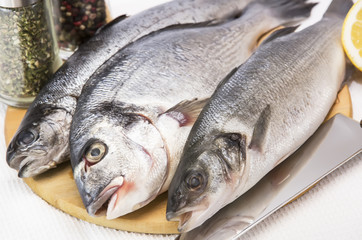 raw fish on a cutting board and knife