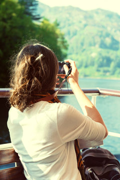 Female enjoying boat ride, taking photos, Scottish Highlands