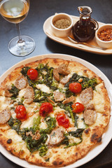 baked paesana pizza with a glass of wine