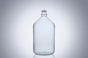 Big glass water bottle demijohn isolated on white background