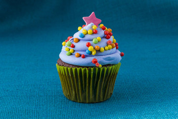 cupcake with blueberry frosting and colorful sprinkles
