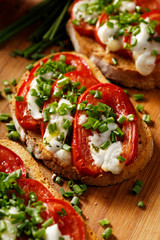 Bruschetta with  tomato,  cheese  and fresh chive