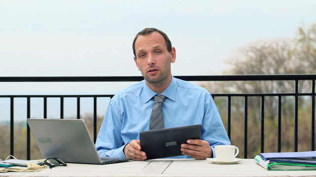 Unhappy, serious businessman talking bad news to camera on terra