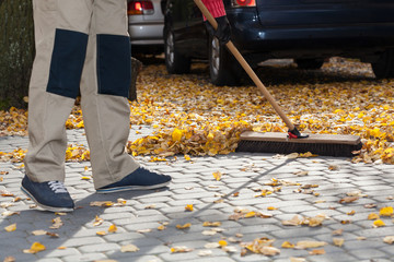 Brooming driveway from leaves